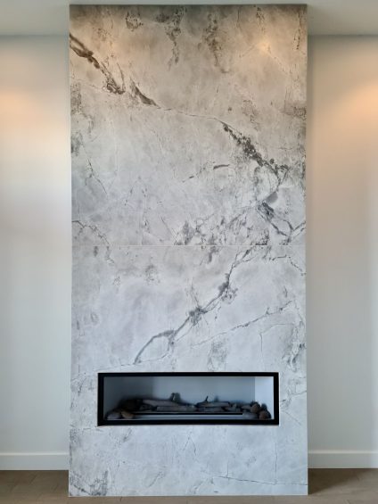 White marble chimney with black fireplace insert.